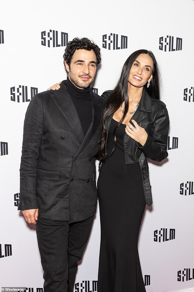 Fashion designer Zac Posen, who supported Demi early in his career, wore a double-breasted sport coat with a turtleneck and jeans at the back.