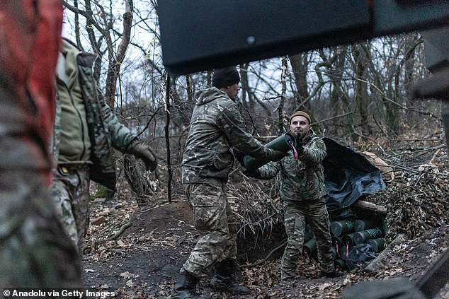 Ukrainian soldiers load ammunition from an armored vehicle at their fighting position in the direction of Toretsk