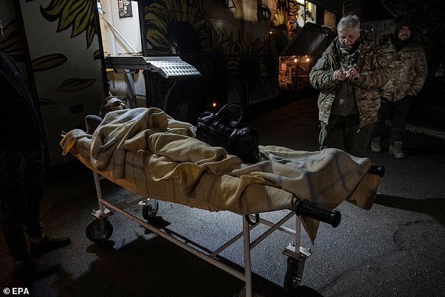 Medical personnel of the Knights Hospitaller carry a wounded Ukrainian soldier in their medical bus for transport to a hospital in the Donetsk region