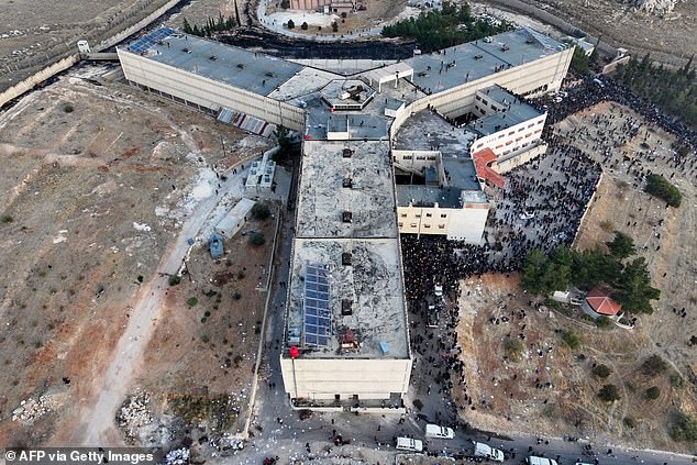 An aerial photo shows people gathering at Sednaya Prison in Damascus on December 9