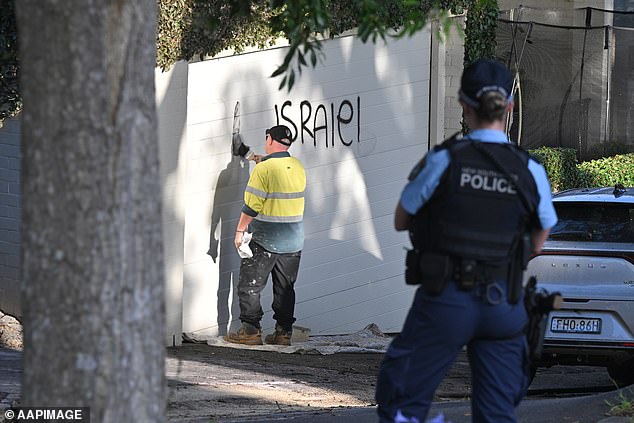 Pictured: A contractor cleaning anti-Israel graffiti in Magney Street, Woollahra