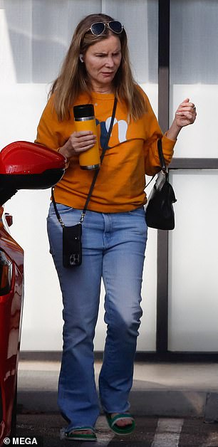 The versatile actress was in an orange sweatshirt with blue jeans and green flip-flops