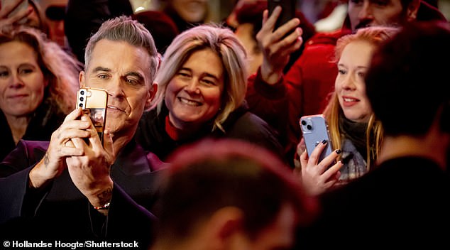 Fans who braved the cold weather looked excited as Robbie took time to take pictures with them at the event