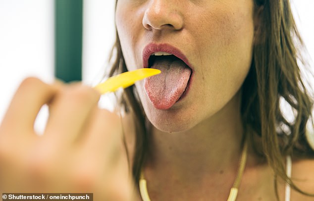 Dentists have revealed the most common symptoms your tongue may be trying to warn you about your health, including white spots, painful lumps or swelling (stock image)