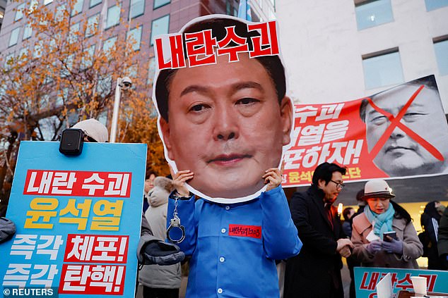 A protester carries a cutout of the president's face. In a somewhat rare event, Rodong Sinmun, the official newspaper of North Korea's ruling party, released a detailed report on last week's tumultuous events in Seoul, including photos of the protests