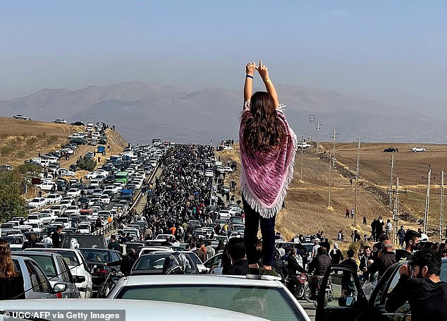 The 2022 protests in Iran, with an unveiled woman standing on top of a car. Amnesty International has condemned new laws that claim women could be sentenced to death for sending videos of themselves to media outside the Islamic Republic.