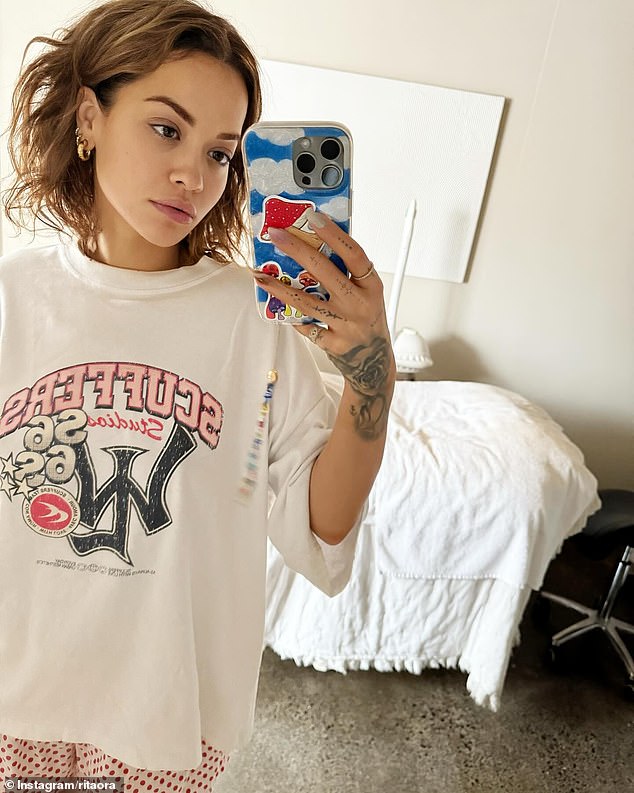 Meanwhile, in another selfie photo, Rita cut a casual figure in an off-white graphic T-shirt as she posed up a storm in a treatment room