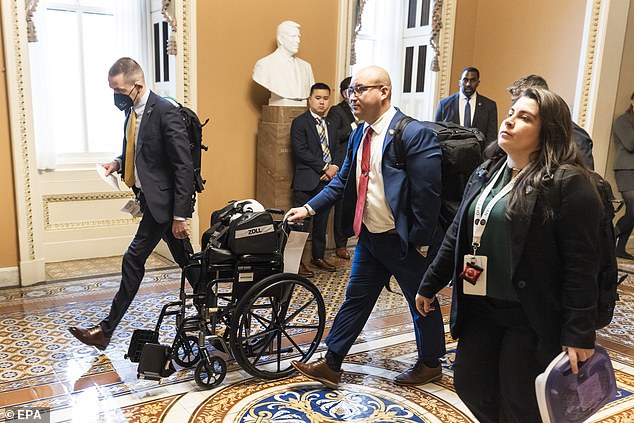 Paramedics roll a wheelchair into Senate Minority Leader Mitch McConnell's office after he fell