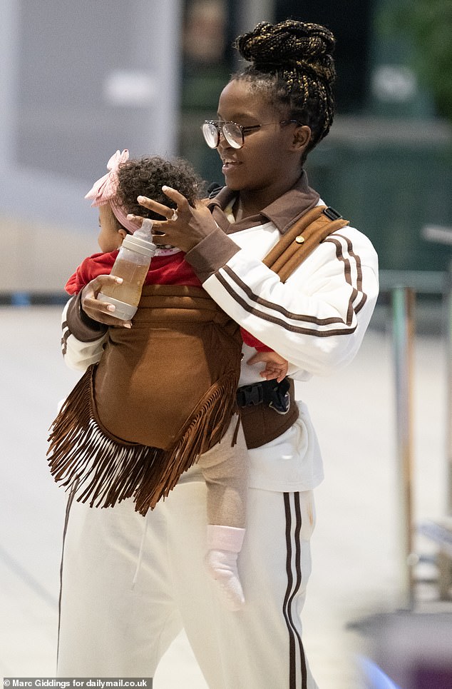 She looked comfortable, ready for the long flight home, in a white and brown tracksuit and trainers