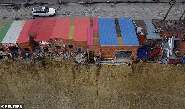 The image shows a thin line of thin structures hanging from the edge of the cliff