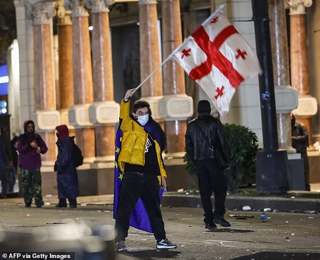 Protesters clash with police during a demonstration against the government's decision to postpone European Union membership negotiations amid a post-election crisis, outside the Georgian parliament in Tbilisi, early December 1, 2024