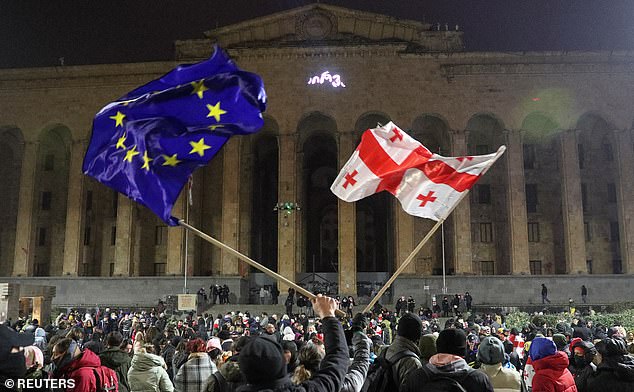 Supporters of Georgia's opposition parties hold a rally to protest the government's decision to suspend talks on joining the European Union, outside the Parliament building