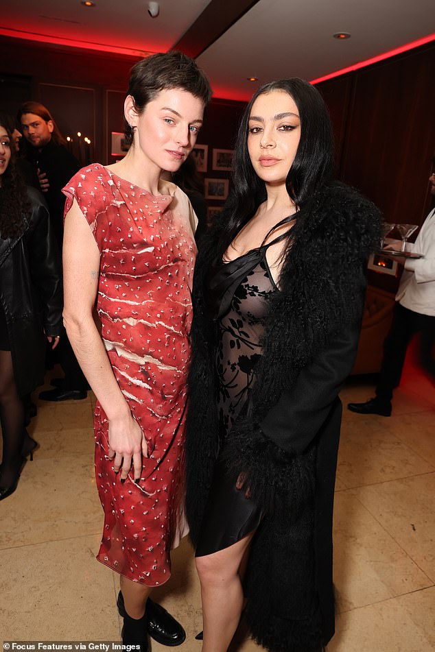 Emma Corrin, 29, wore a red printed dress and black ankle boots, while Charli, 32, also looked fantastic as she went braless in a sheer black dress with floral detailing on the bodice