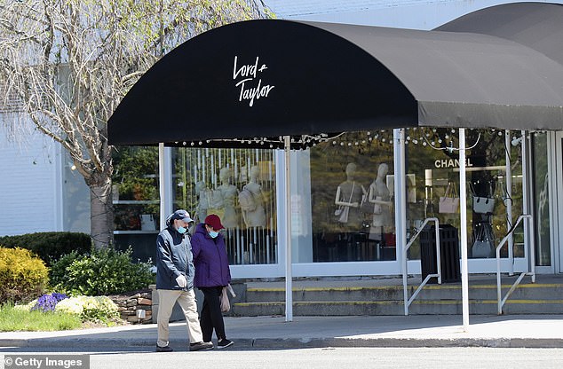 Pedestrians walk past a closed Lord and Taylor department store following their bankruptcy filing during the COVID-19 pandemic in May 2020