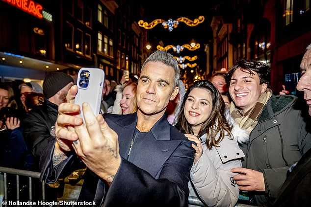 It comes after Robbie couldn't contain his excitement as he posed for selfies with fans at the Better Man premiere in the Netherlands on Tuesday night.