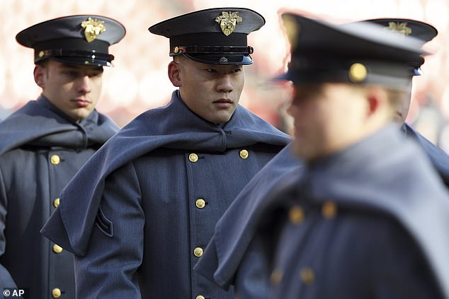 Army cadets walk onto the field Saturday for a college football game against Navy