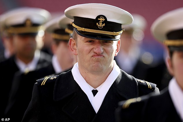 Navy midshipmen walk onto the field Saturday for a football game against the Army