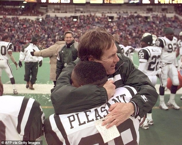 Belichick hugs Jets defenseman Anthony Pleasant after winning the AFC East title