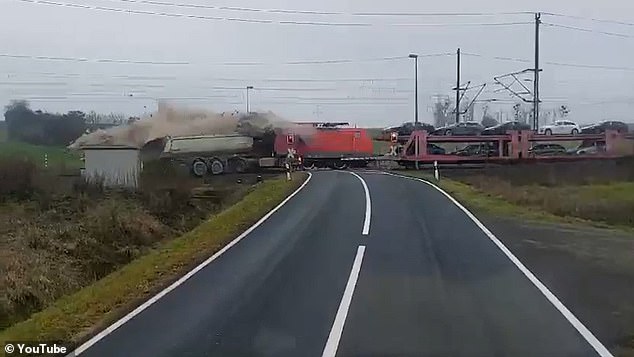 The freight train, carrying several brand new Audis, crashed into the truck and dragged it at high speed as the driver desperately tried to brake.