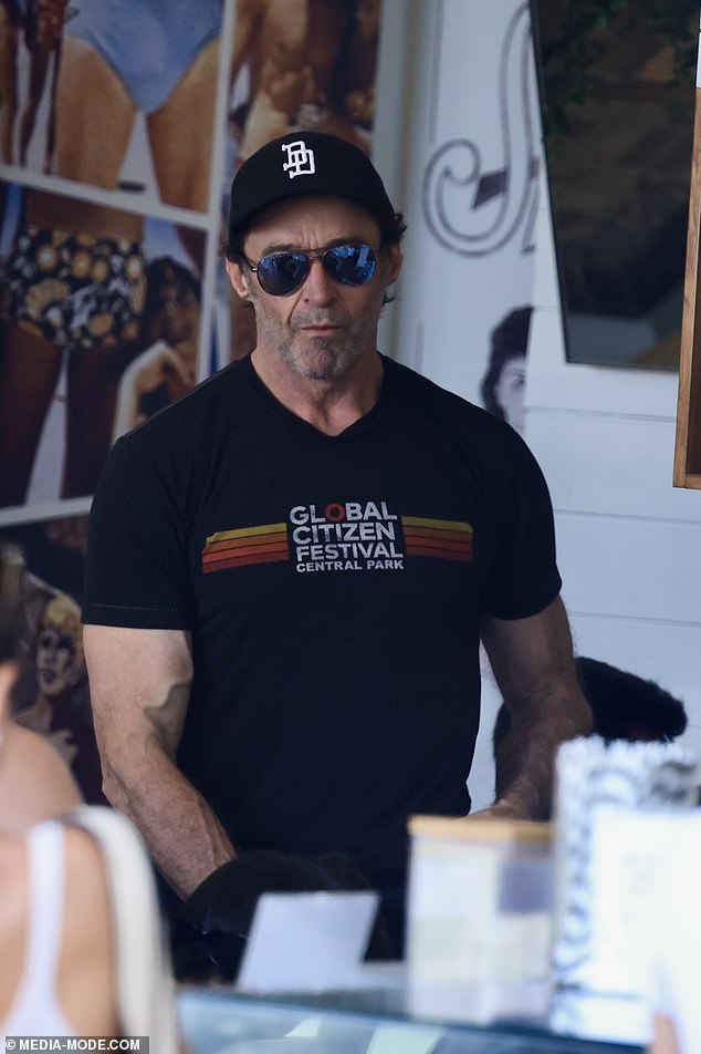 Hugh dressed comfortably for the outing in a fitted black shirt and shorts