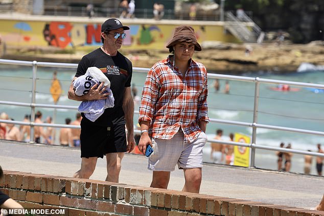 Hugh's son Oscar wore white shorts and a red checked shirt paired with a brown bucket hat