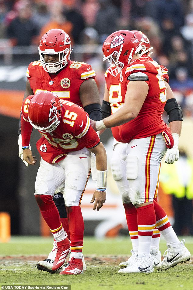 Chiefs quarterback Patrick Mahomes (15) staggers off the field with the help of teammates