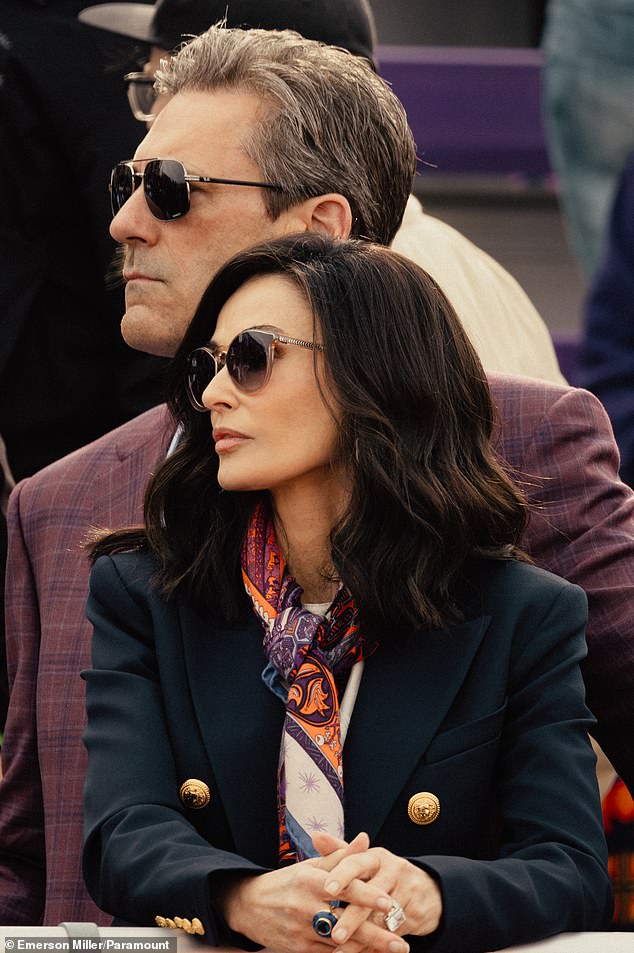 Moore is also seen in a blazer with beautifully styled hair as she watches her daughter win a sprint; Hamm is also seen, but he is distracted by a work visit