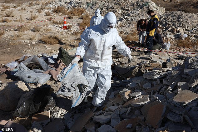 Members of Syria's Civil Defense Group, the White Helmets, work at the site where several bodies and human bones were discovered