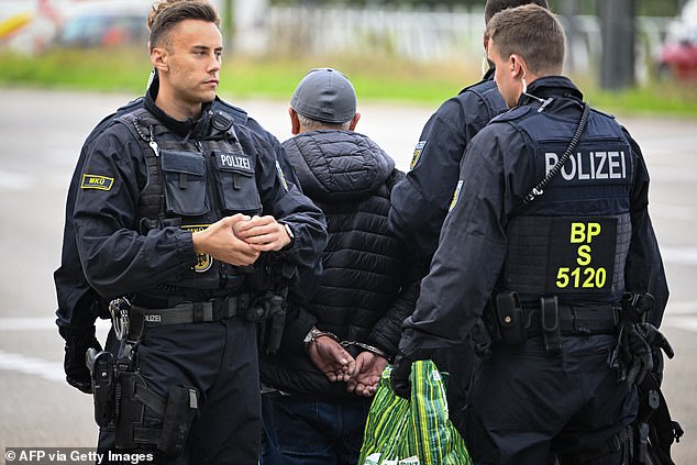 Officers arrest a man at the German-French border in Kehl, West Germany