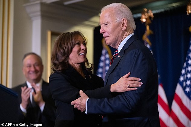 US Vice President Kamala Harris hugs US President Joe Biden before speaking at the Democratic National Committee holiday reception i