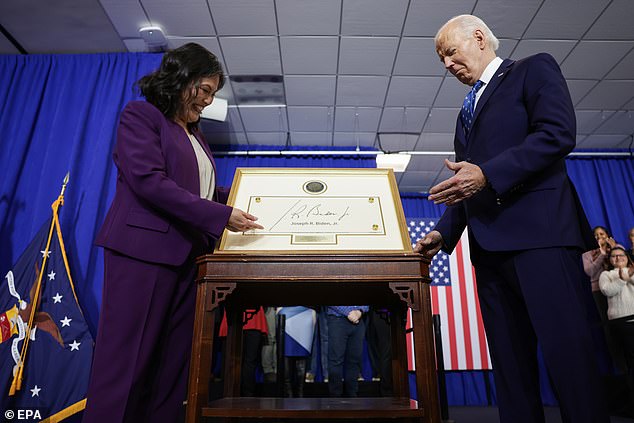 President Joe Biden receives a plaque from Acting Secretary of Labor Julie Su during an event at the U.S. Department of Labor