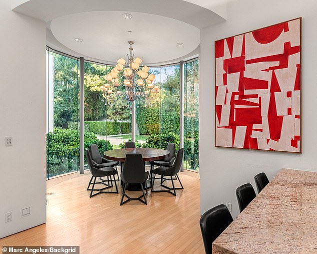 A red and white work of art hangs on the kitchen wall