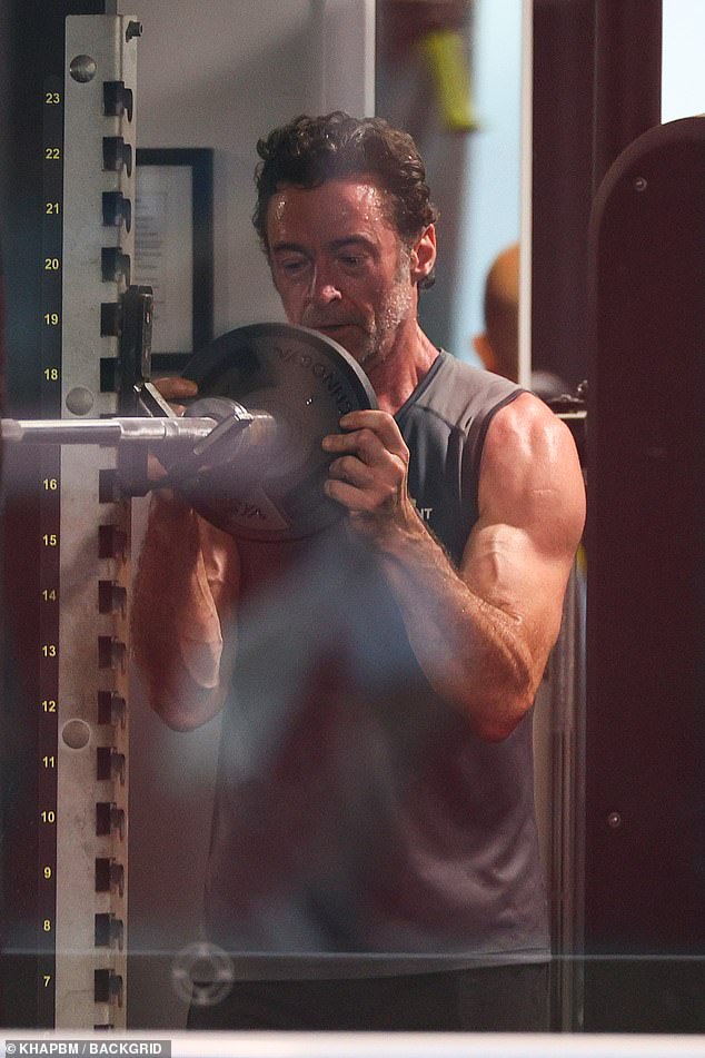 The Australian actor, 56, showed off his bulging biceps in a singlet as he performed a shoulder press with dumbbells at a gym in Bondi