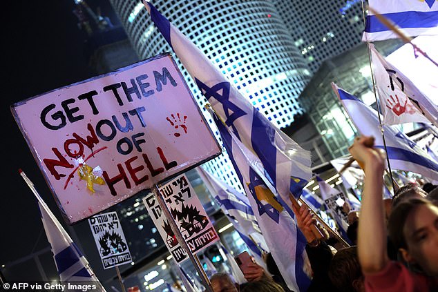 Protesters raise banners and wave flags during an anti-government protest demanding action for the release of Israelis held hostage in Gaza