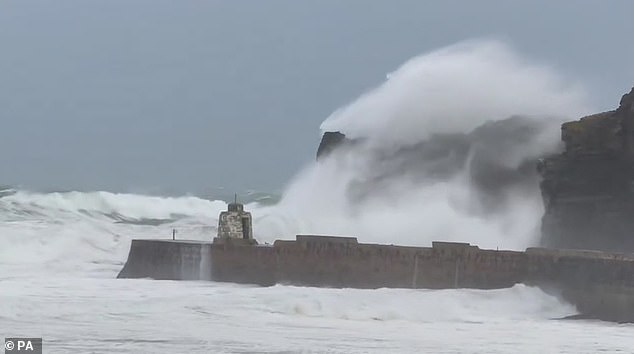 The Environment Agency says rising sea levels and more intense storms due to climate change put more than 100,000 homes at risk of being destroyed by coastal erosion before the end of the century. Pictured: Storm Darragh hits the Cornish coast