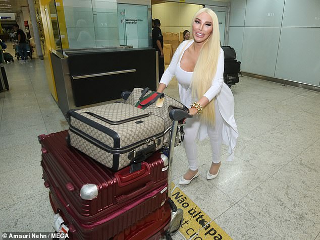 Jessica looked cheerful as she walked through the arrivals hall with her two large red suitcases and two Gucci carry-on bags