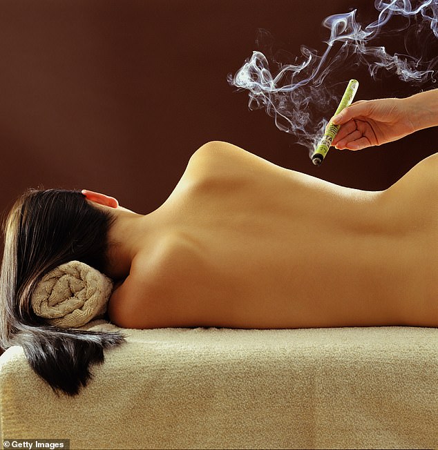 Moxibustion is a traditional Chinese medicine treatment that involves burning a dried herb called 'moxa' on or near the skin to stimulate the flow of qi or 'life force' (stock image)