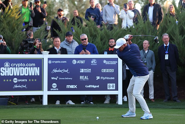 LIV Golf star Koepka hits his drive on the third hole as VIPs watch from behind the tee box