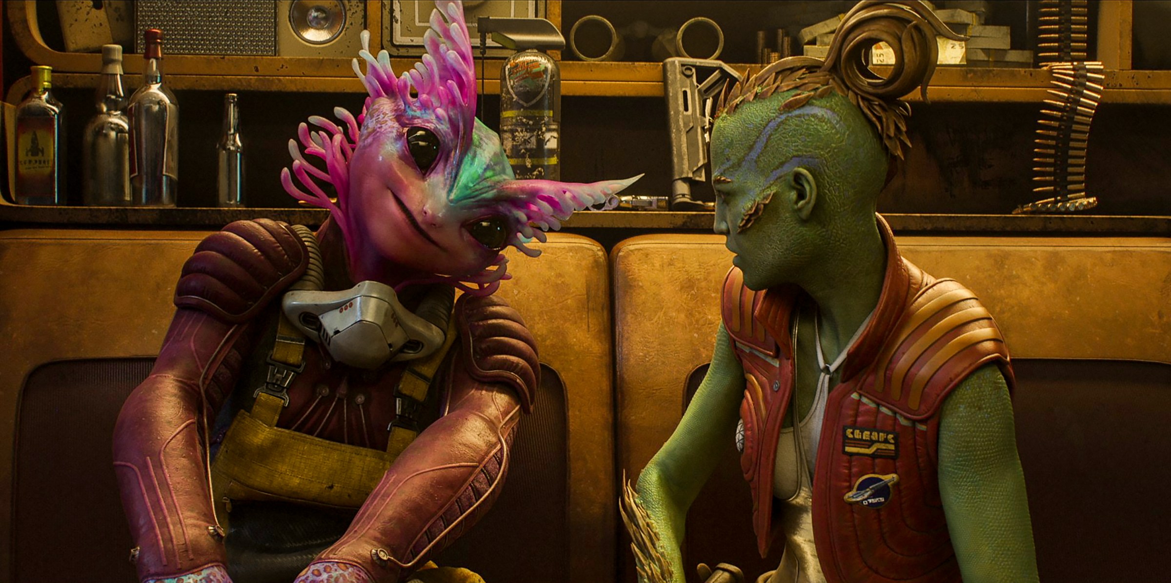 An alien with pink facial tendrils and one with a green shaved head with feathered curls sit together on an orange couch in the Concord episode of Secret Level