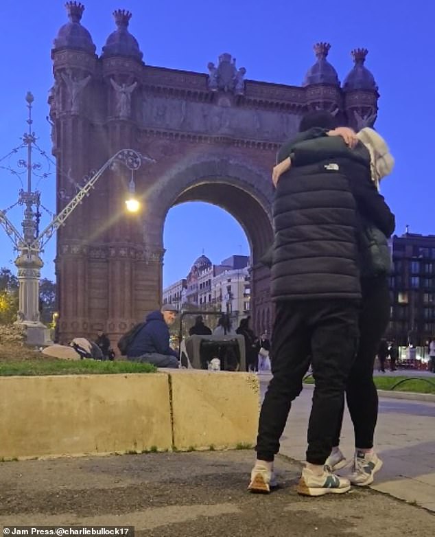 The two pause to embrace, leaving the phone unattended as the audience watches