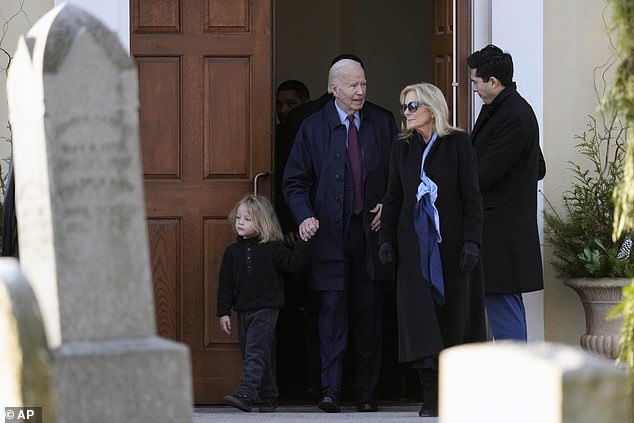 Baby Beau holds hands with President Biden, next to first lady Jill Biden, as they leave the church