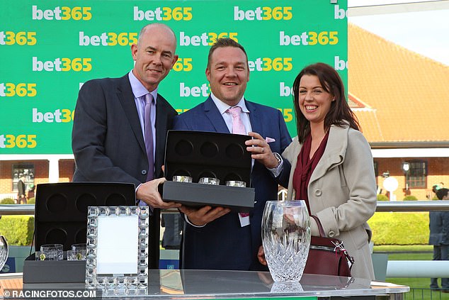 John Dance (centre) collects a trophy at Newmarket after his horse Laurens was the winner