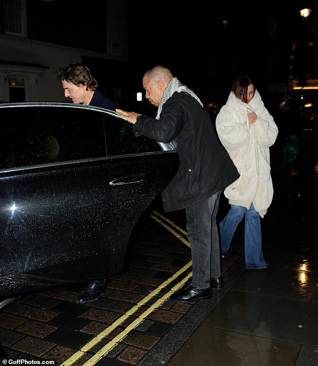 Dressed in a dark coat, the Mission: Impossible star was accompanied by the burley security guard as the unidentified lady stepped onto the sidewalk and drove away