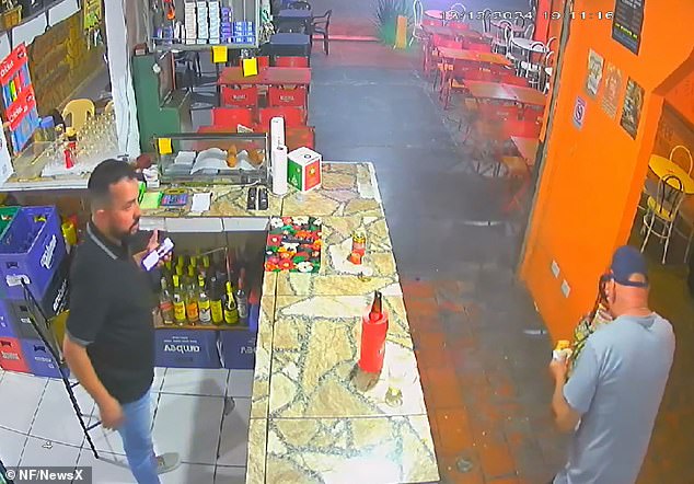 The store's owner, Christian de Souza Amaral, who witnesses the snack eruption, stands open-mouthed in shock as the dazed customer tries to wipe the burning filling from his face