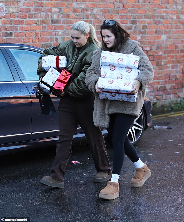 The influencer, who was accompanied by her friend Erin, grabbed the gifts from the trunk of her Mercedes G Wagon, wearing brown sweatpants and a bomber jacket.