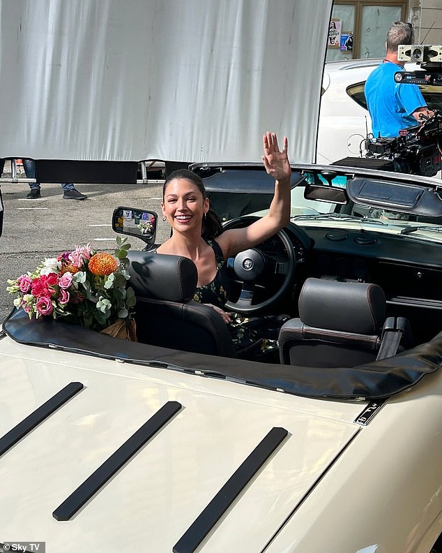 Ursala waved to the cameras as she filmed scenes in an open car