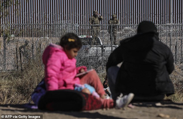 Migrants approach a fence guarded by the Texas National Guard in Ciudad Juarez, Chihuahua state, Mexico, on December 18, 2024, as they attempt to enter the United States to seek asylum on International Migrant Day