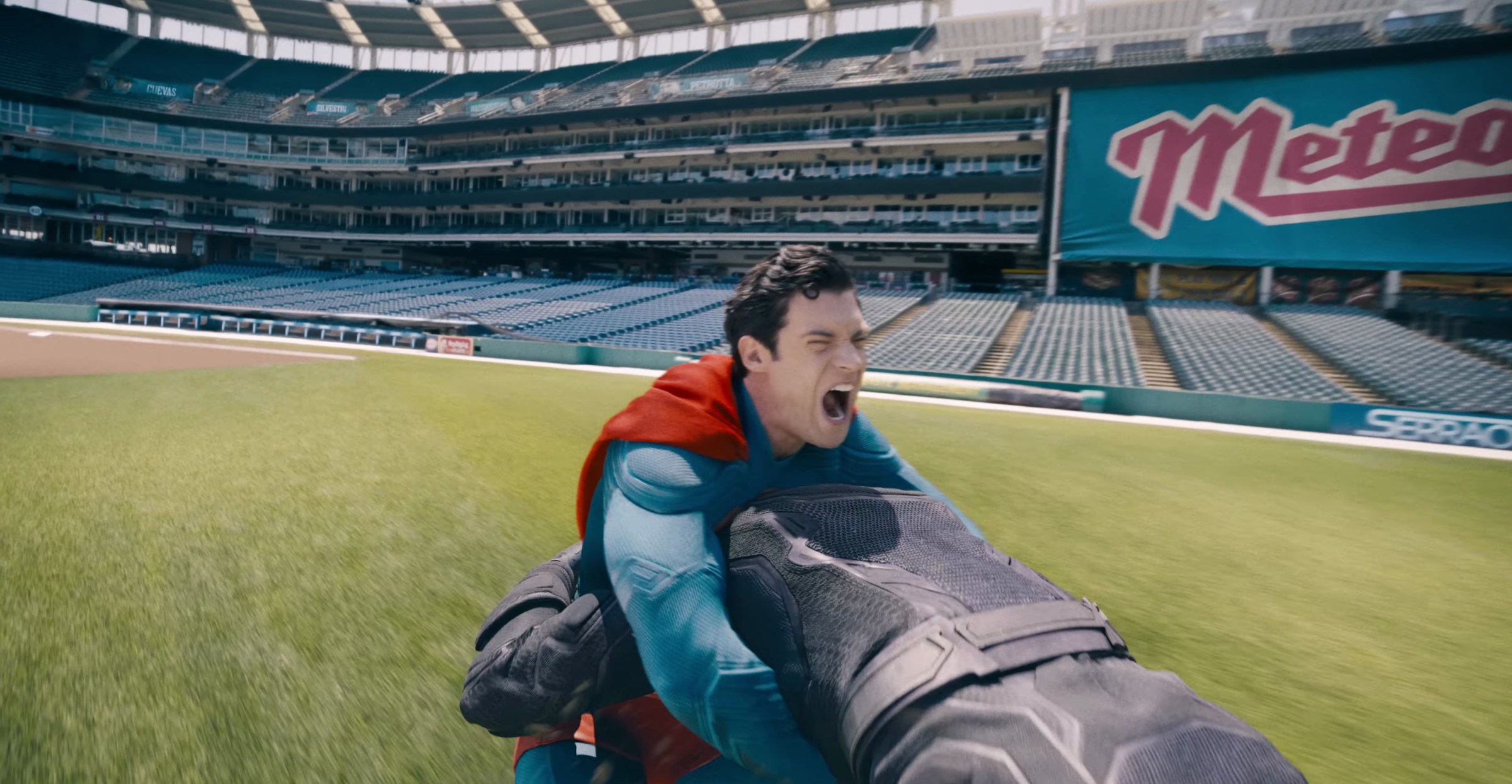 Superman fights a man in black leather on a baseball field in Superman 2025