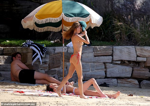 Max, 31, (left) was photographed with his ex Dina, 46, at Kutti Beach in Sydney on Tuesday. The famous 'nude artist' even sunbathed topless