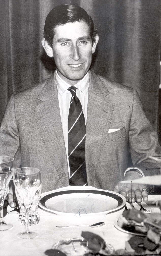 Prince Charles sits at a dining table after attending a Christmas service in 1982